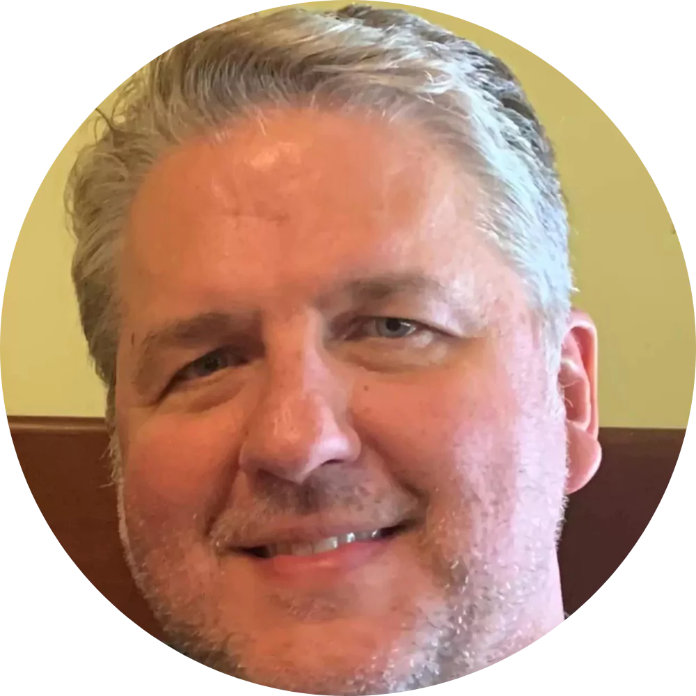 Smiling man with gray hair and beard